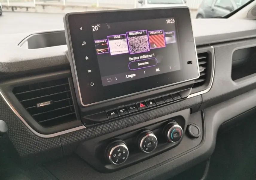 Vue rapprochée du tableau de bord du Nissan Primastar 2025 avec écran tactile et commandes de climatisation.