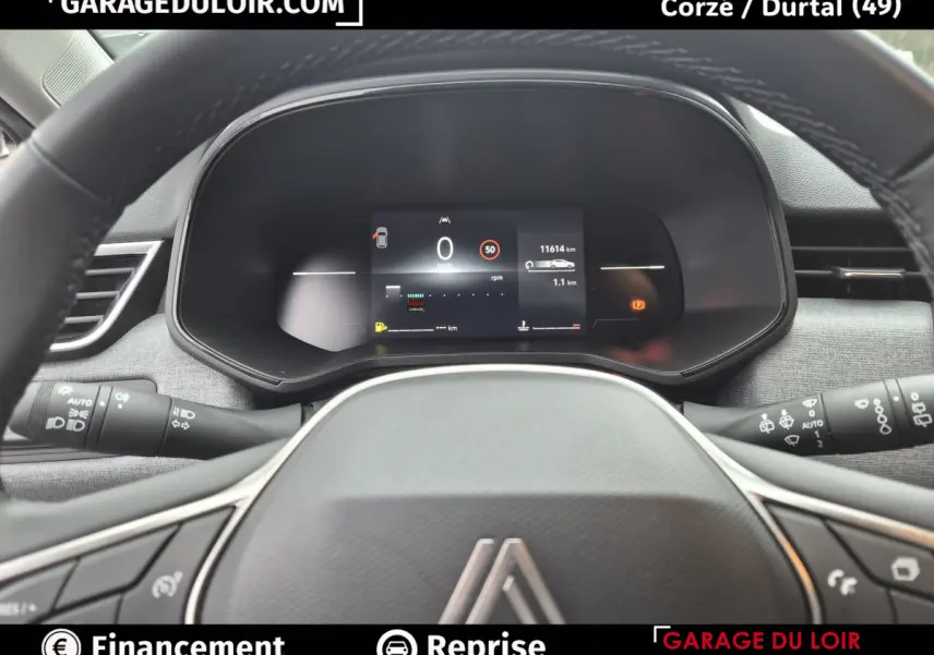 Vue rapprochée du tableau de bord numérique et du volant en cuir synthétique de la Renault Clio gris clair Evolution TCe 90 -25.