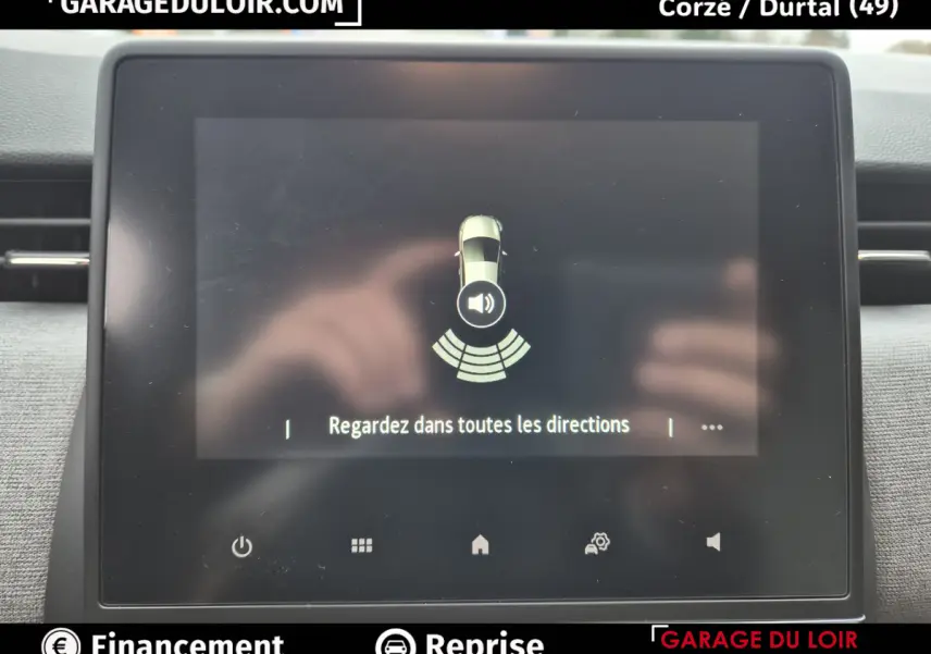 Écran tactile central de la Renault Clio gris clair affichant une alerte de surveillance des angles morts.