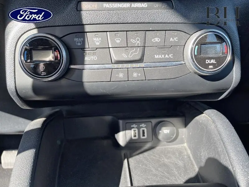 Vue rapprochée de la console centrale du Ford Kuga 2022, montrant les commandes de climatisation et ports USB.