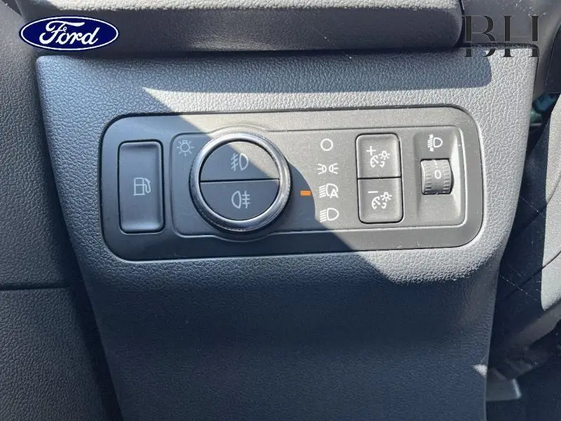 Gros plan sur les commandes d’éclairage noires du tableau de bord du Ford Kuga gris Magnetic Métallisé.