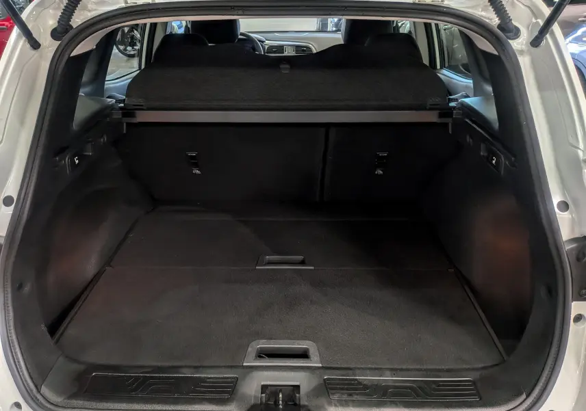 Coffre ouvert vu de l'arrière d'un Renault Kadjar Blanc Glacier 2021, avec cache-bagages et intérieur noir.