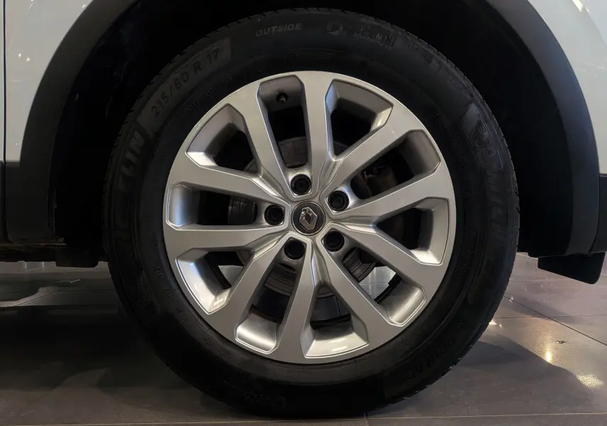 Gros plan sur la roue avant droite du Renault Kadjar blanc Glacier avec jante alliage 17 pouces et logo central Renault.