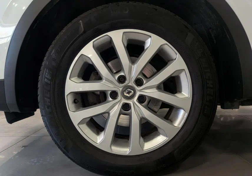 Gros plan sur la jante alliage argentée avec logo Renault, montée sur un pneu Michelin d’un Kadjar Blanc Glacier.