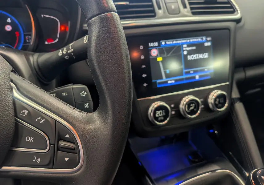 Vue rapprochée du volant et de la console centrale du Renault Kadjar 2021, avec écran tactile et commandes de climatisation visibles.