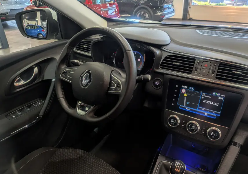 Vue intérieure côté conducteur du Renault Kadjar blanc Glacier 2021, tableau de bord avec écran tactile et volant multifonction.