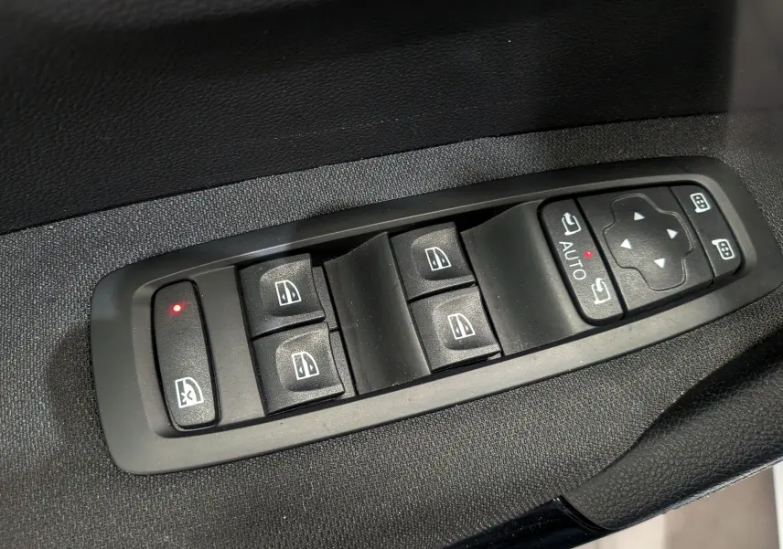 Gros plan sur les commandes de lève-vitres et rétroviseurs électriques côté gauche du Renault Kadjar blanc Glacier 2021.