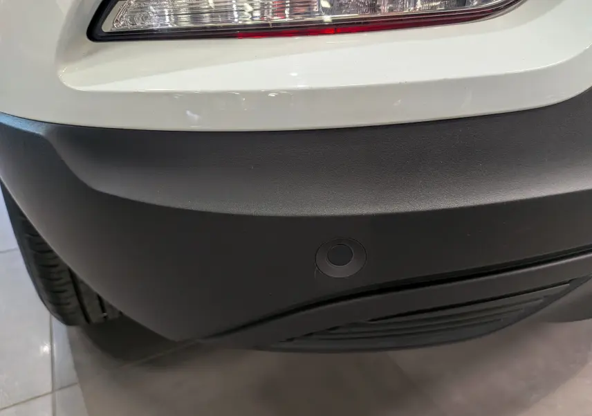 Gros plan sur le pare-chocs arrière noir et feu blanc glacier du Renault Kadjar 2021, avec capteur de recul visible.