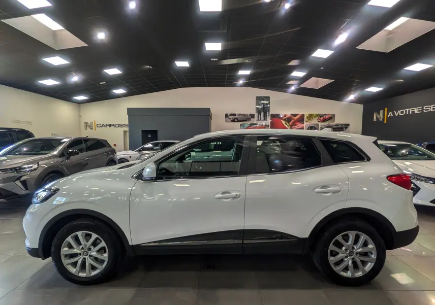 Renault Kadjar Blanc Glacier vue de profil côté gauche dans un showroom lumineux avec jantes alliage 17 pouces.