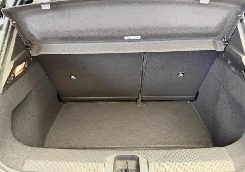 Vue intérieure du coffre ouvert de la Renault R5 E-Tech Electrique 120 noir étoilé, montrant un espace de rangement propre et vide.