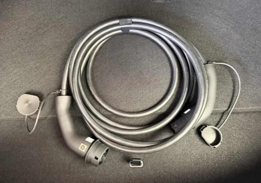 Câble de recharge électrique enroulé dans le coffre d'une Renault R5 E-Tech Noir Étoilé, vue rapprochée du câble.