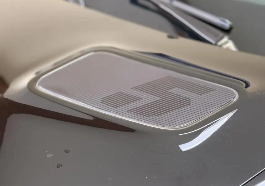 Gros plan sur le capot noir étoilé de la Renault R5 E-Tech avec logo "5" stylisé en relief.