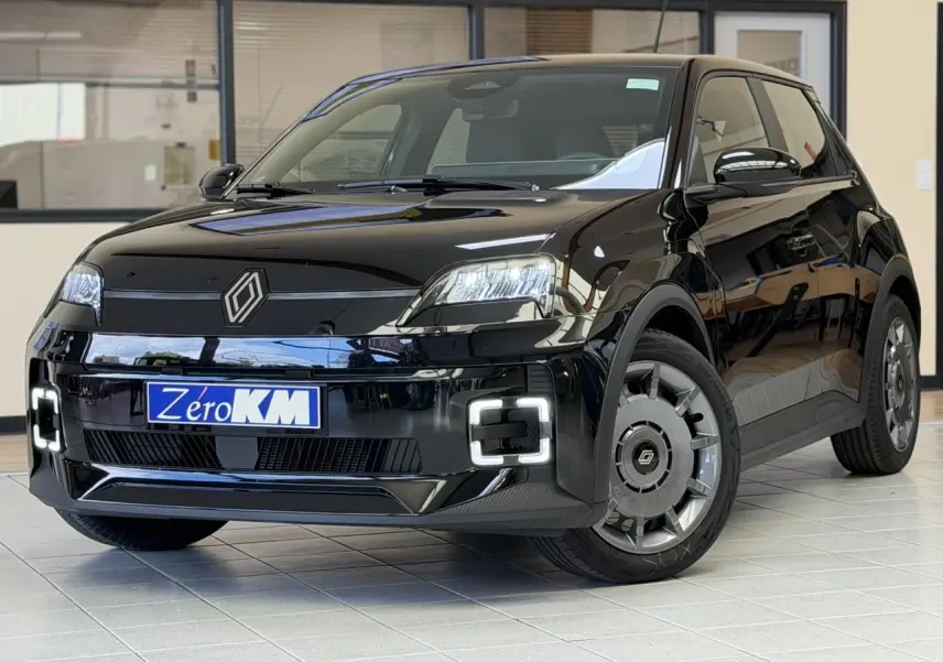Renault R5 E-Tech électrique noir étoilé vue 3/4 avant avec phares et feux LED distinctifs en intérieur showroom.