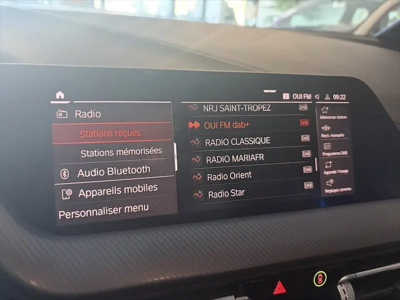 Écran central de la BMW Série 1 noir métal 2020 affichant le menu radio avec stations DAB+ en intérieur.