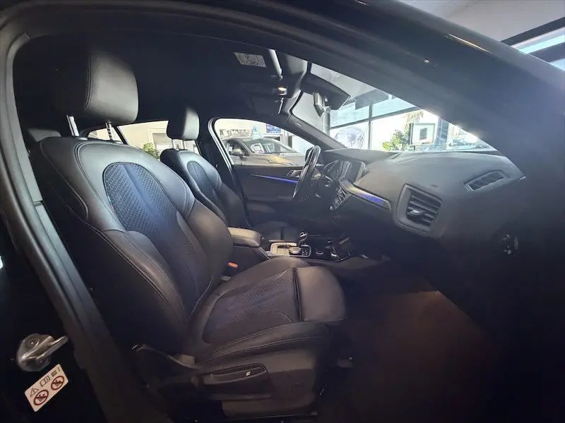 Intérieur de la BMW Série 1 118D 2020 en noir, vue côté conducteur montrant sièges et tableau de bord M Sport.