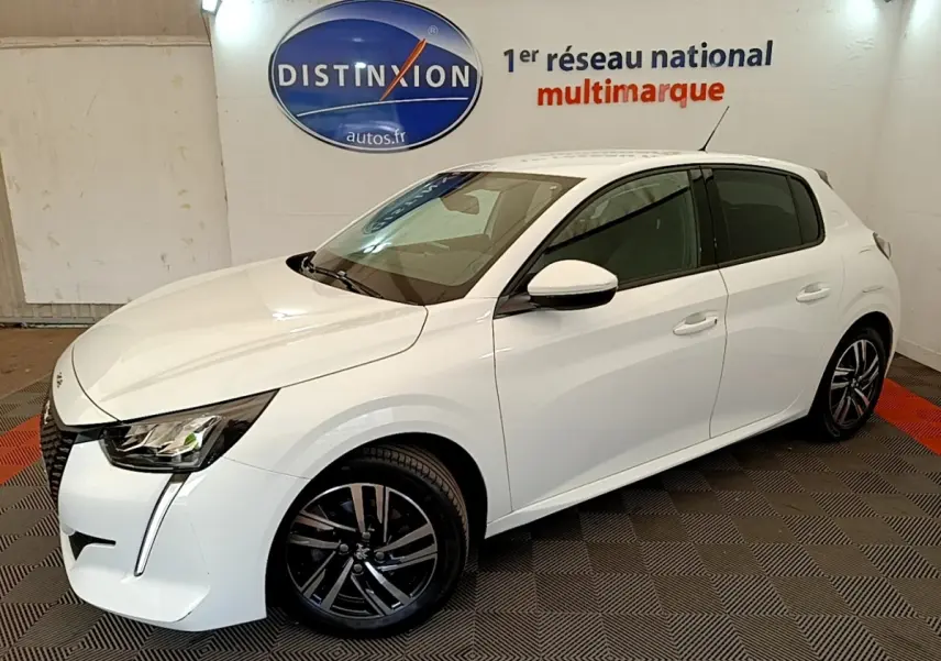Peugeot 208 blanc vue 3/4 avant droit, avec jantes alliage noires et phares LED distinctifs.