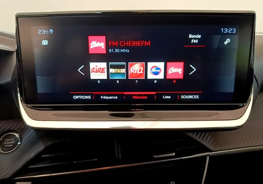 Écran tactile 10 pouces du système multimédia de la Peugeot 208 blanche, vue frontale du tableau de bord.