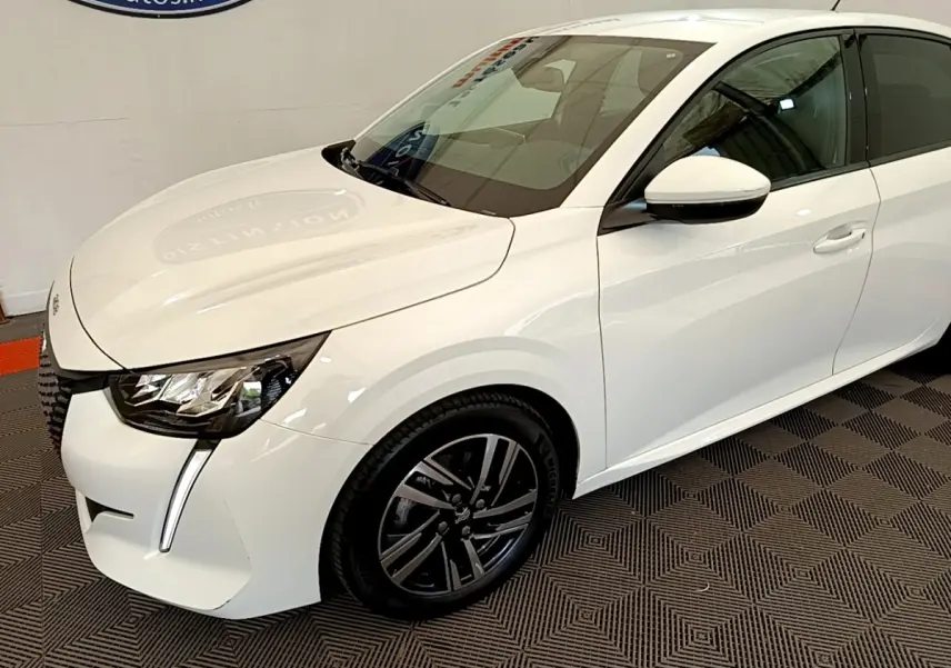 Peugeot 208 blanc vue 3/4 avant droit, avec phares LED et jantes alliage noires distinctives.