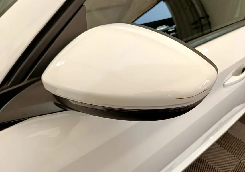 Gros plan sur le rétroviseur droit blanc d'une Peugeot 208 PureTech 100 S&S Allure Business 2021.