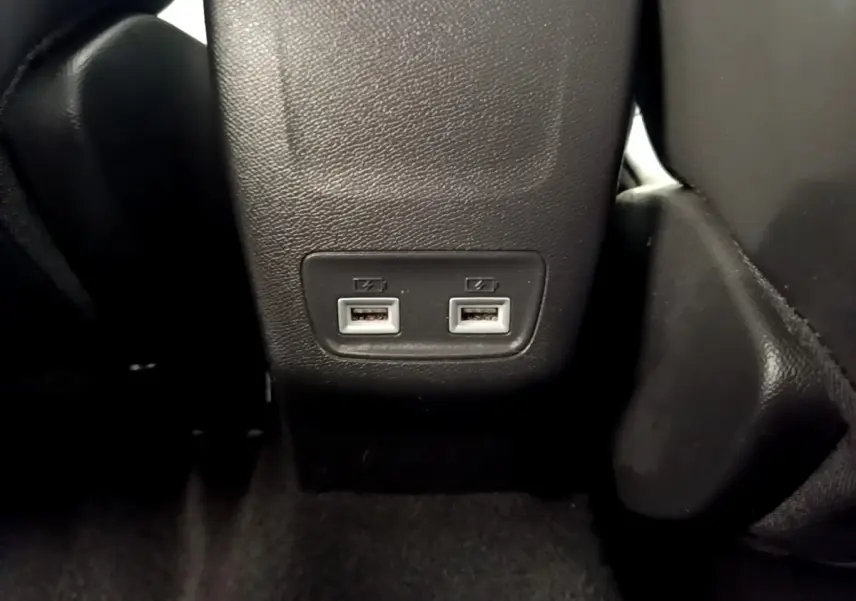 Gros plan sur les deux ports USB arrière intégrés à la console centrale d’une Peugeot 208 blanche.