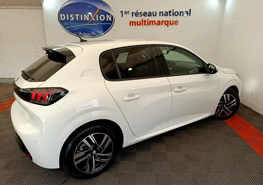 Peugeot 208 blanc vue 3/4 arrière droit, feux arrière LED griffés et jantes alliage noires et argentées.