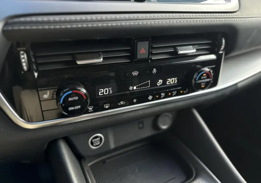 Détail de la console centrale du Nissan Qashqai 2025, montrant la climatisation automatique bi-zone et le bouton Start/Stop.