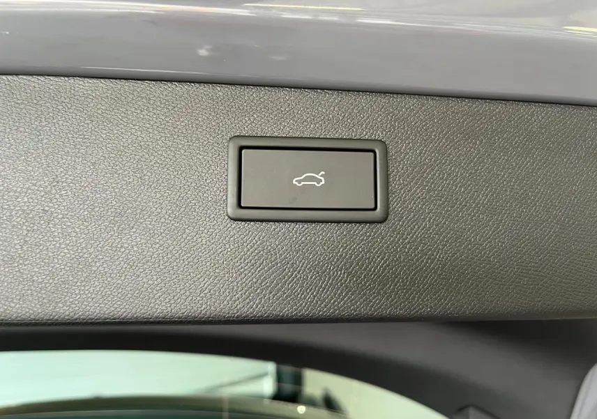 Bouton d'ouverture électrique du hayon sur la garniture intérieure du coffre du CUPRA Formentor gris clair.