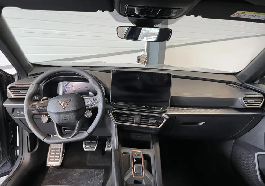 Intérieur avant du CUPRA Formentor gris clair 2025, volant cuir avec logo cuivré et écran tactile central HD.