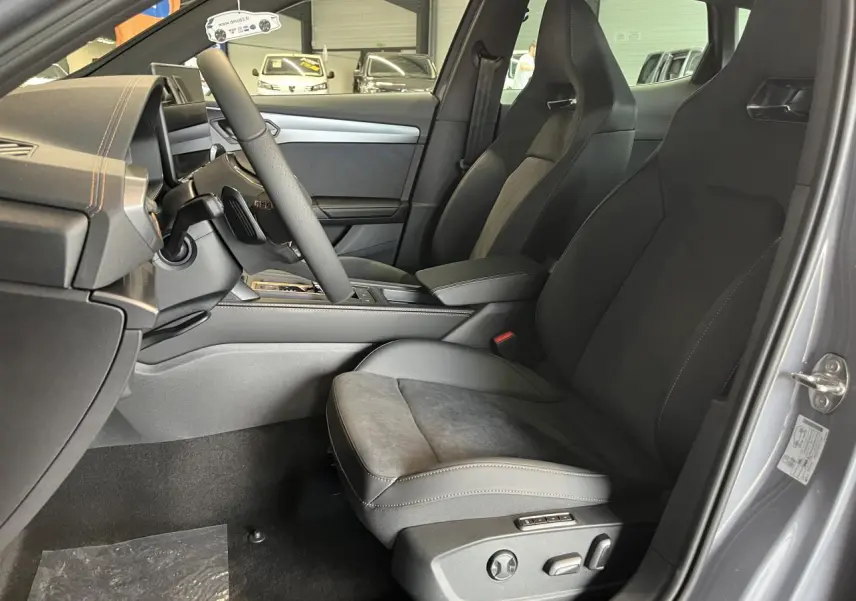 Vue intérieure côté conducteur du CUPRA Formentor gris clair 2025, sièges sport en cuir et alcantara avec surpiqûres contrastantes.
