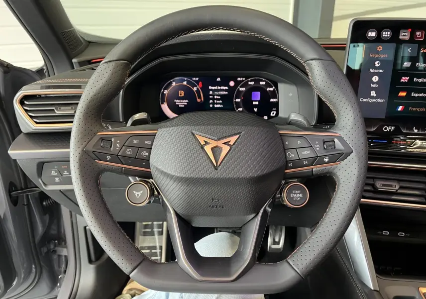 Vue frontale du volant perforé noir avec logo CUPRA cuivré et tableau de bord digital du CUPRA Formentor 2025.