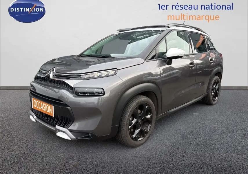 Citroën C3 Aircross gris platinium en 3/4 avant droit, avec jantes noires et rétroviseurs blancs.
