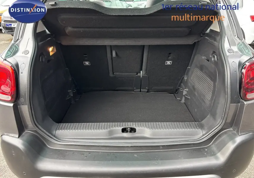 Coffre ouvert vu de l’arrière d’un Citroën C3 Aircross 2021 gris platinium, montrant l’espace de chargement vide.