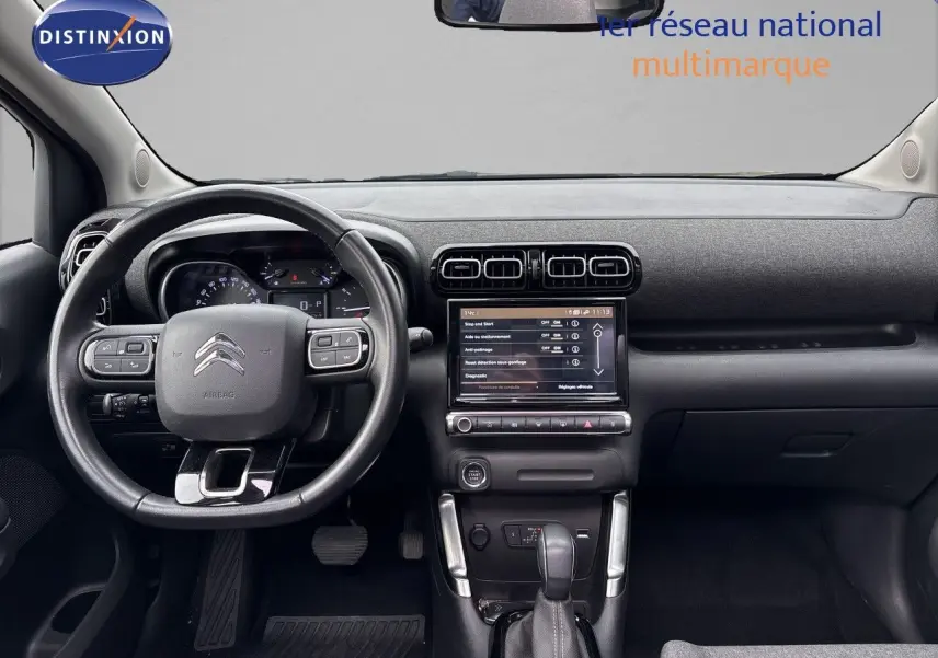 Vue intérieure frontale du tableau de bord et volant noir de la Citroën C3 Aircross Shine Gris Platinium 2021.