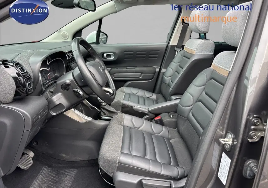 Vue intérieure côté conducteur du Citroën C3 Aircross gris platinium, sièges mixtes cuir et tissu avec détails beige.