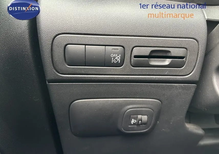 Détail intérieur montrant les commandes de réglage des phares et des fonctions sur la planche de bord noire du Citroën C3 Aircross.