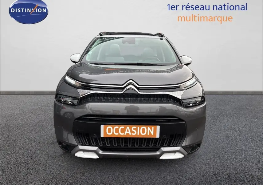 Vue avant d'un Citroën C3 Aircross gris platinium avec calandre noire et détails blancs sous le pare-chocs.