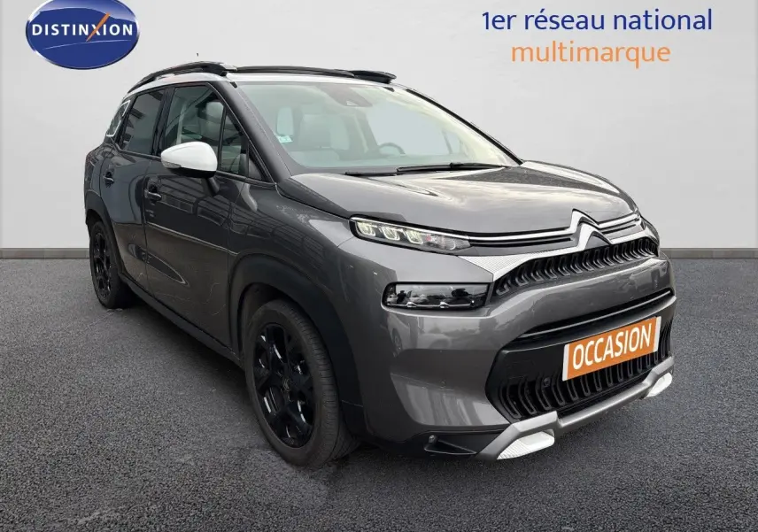 Citroën C3 Aircross gris platinium en 3/4 avant droit, avec jantes noires et coques de rétroviseurs blanches.