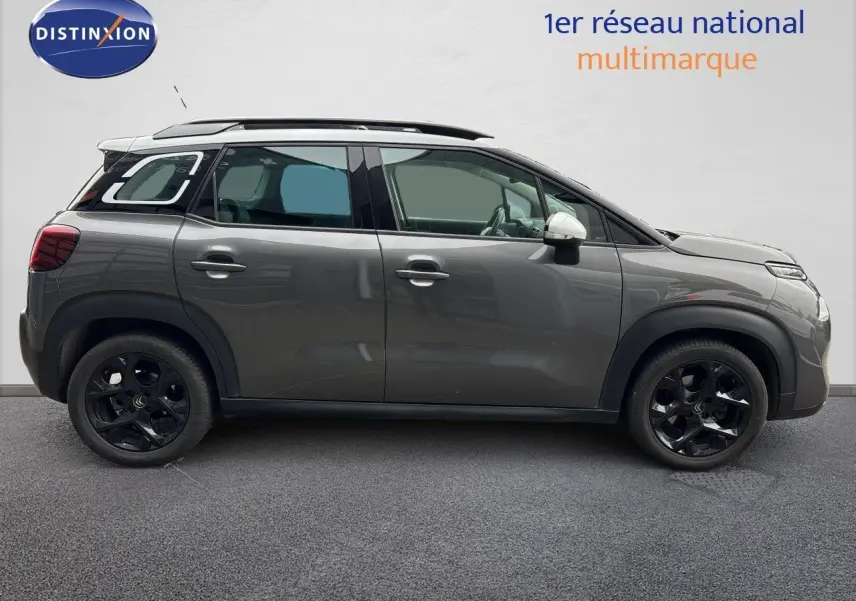 Profil droit d'une Citroën C3 Aircross Shine gris platinium avec toit noir et jantes noires, vue extérieure latérale.