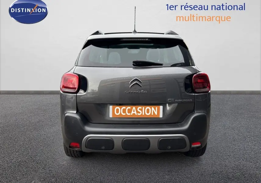 Vue arrière d'un Citroën C3 Aircross gris platinium avec feux rouges et plaque "OCCASION" visible.