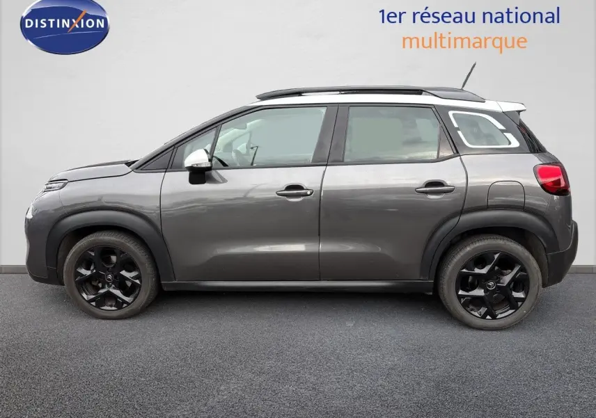 Profil droit d'une Citroën C3 Aircross gris platinium avec toit blanc et jantes noires, vue sur fond neutre.