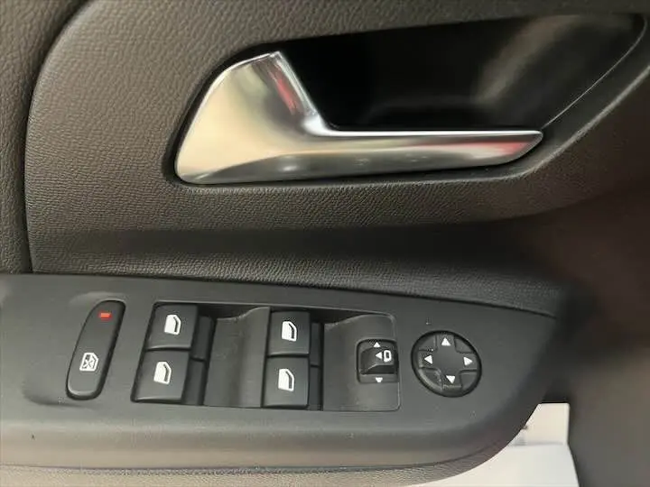 Poignée intérieure et commandes des vitres électriques côté conducteur d'une Opel Corsa rouge Kardio 2021.