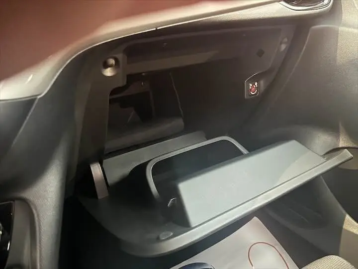 Gros plan sur la boîte à gants ouverte de l'Opel Corsa 1.2T 100 CH S&S GS-LINE, intérieur noir.