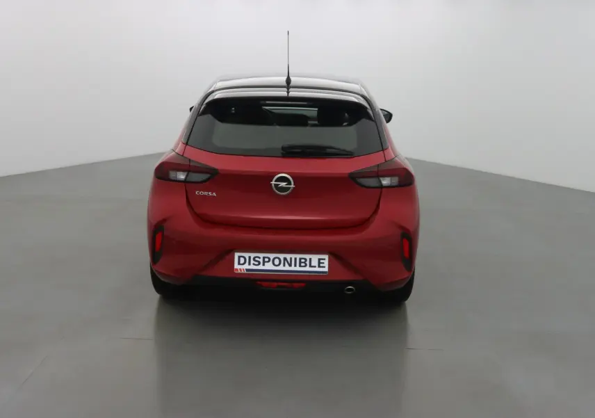 Vue arrière d'une Opel Corsa rouge Kardio avec feux sombres et plaque "DISPONIBLE" visible.