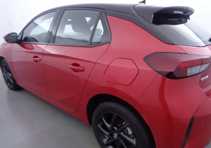 Opel Corsa rouge Kardio vue 3/4 arrière côté gauche, avec jantes noires et toit noir contrasté.