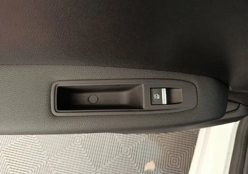 Gros plan sur le bouton de commande de la vitre électrique côté conducteur du Renault Captur blanc 2025.