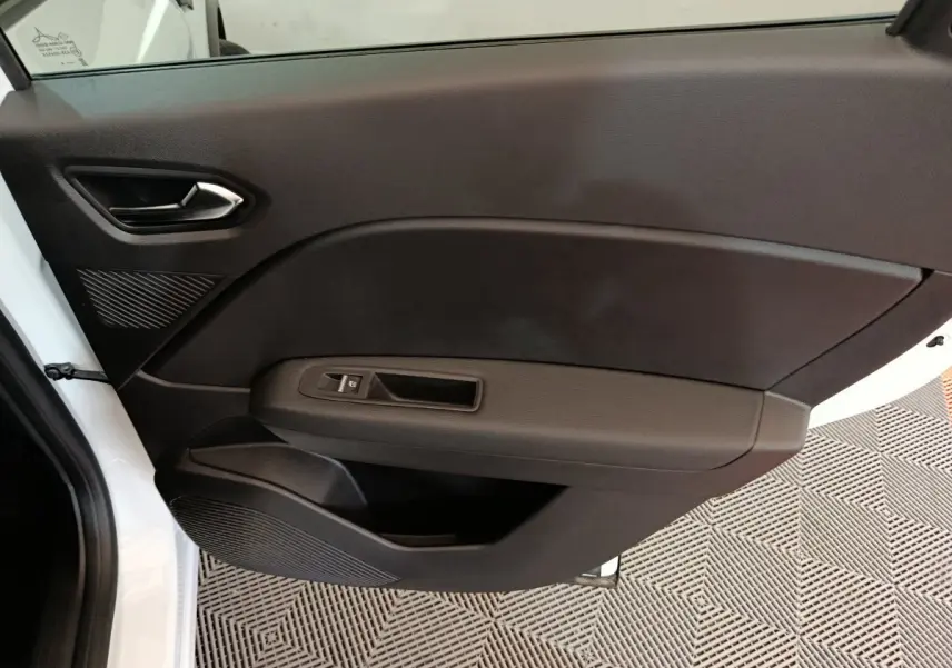 Vue intérieure de la porte côté gauche noire du Renault Captur blanc 2025 avec poignée et commande de fenêtre électrique.