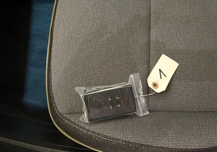 Gros plan sur la clé de démarrage Renault Captur 2025 posée sur un siège tissu gris foncé.