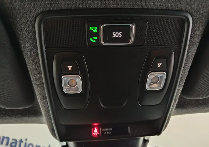 Vue en contre-plongée du panneau de commande de toit noir avec bouton SOS et éclairages intérieurs dans un Renault Captur blanc 2025.