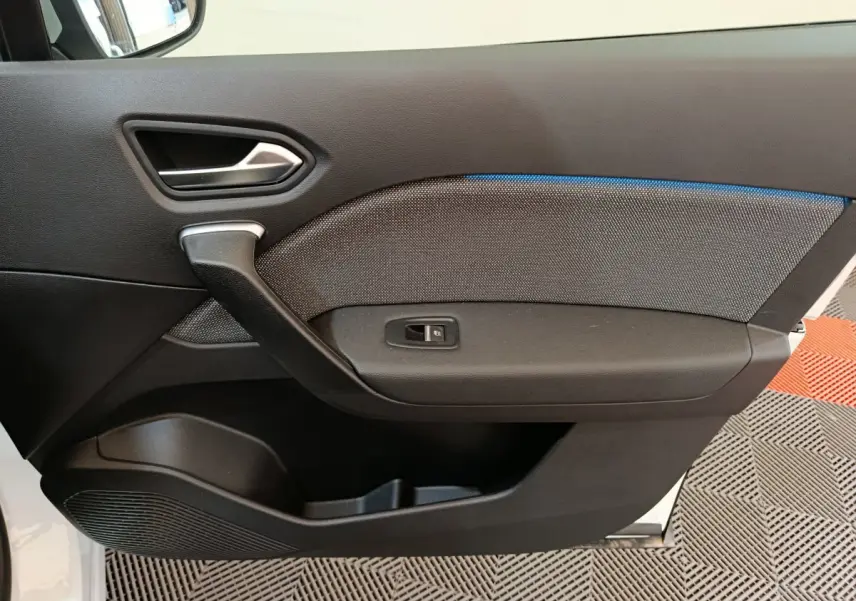 Panneau de porte intérieur côté gauche du Renault Captur blanc 2025 avec éclairage d'ambiance bleu et commande de vitre.