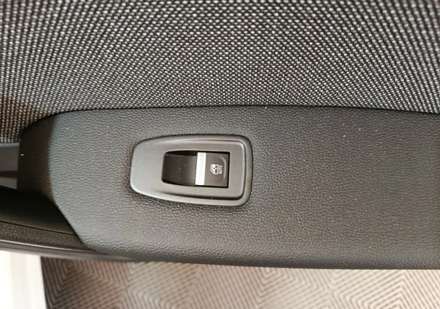 Bouton de commande de lève-vitre électrique sur la portière intérieure d'un Renault Captur blanc 2025.